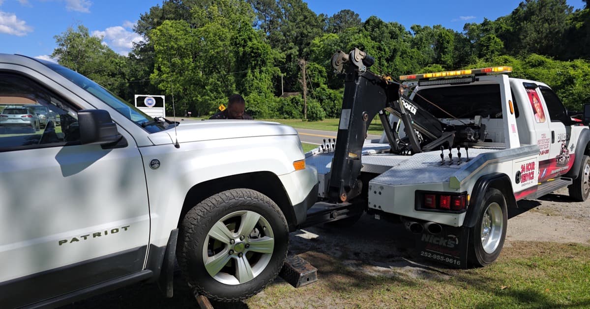Divadon Transport & Towing wrecker hauling a Jeep Patriot in Greenville, NC